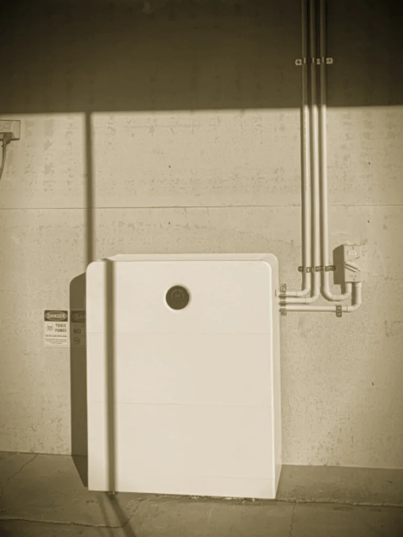 A white battery stack installed by Primero against a sunlit wall